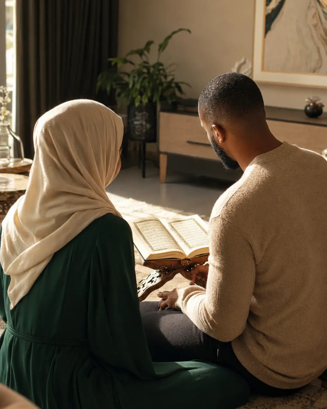 A Black South African Muslim couple reading the Qur’an together in a warm modern home, photographed from behind